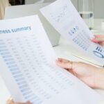 Two business professionals analyzing reports in a modern office setting.