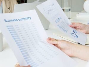 Two business professionals analyzing reports in a modern office setting.